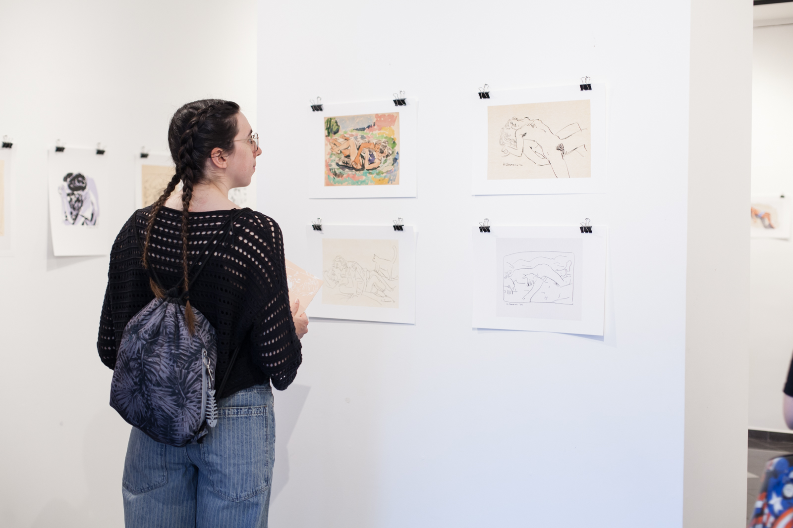 Fotografija niza crteža i jedne osobe koja promatra postav.